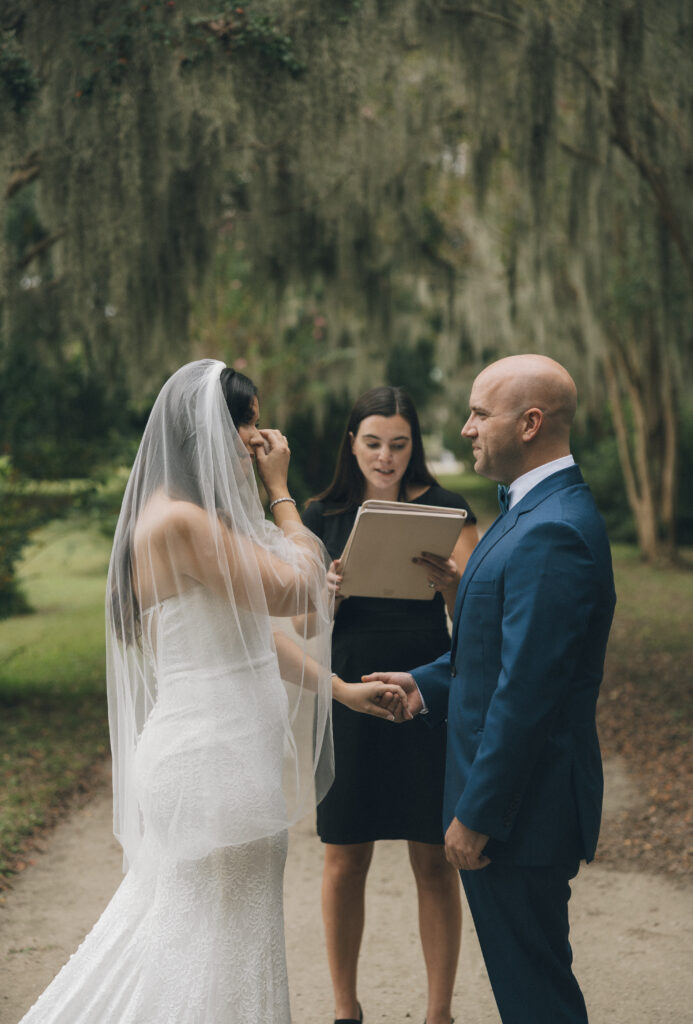 A bride and groom share intimate vows at their outdoor Charleston wedding ceremony.