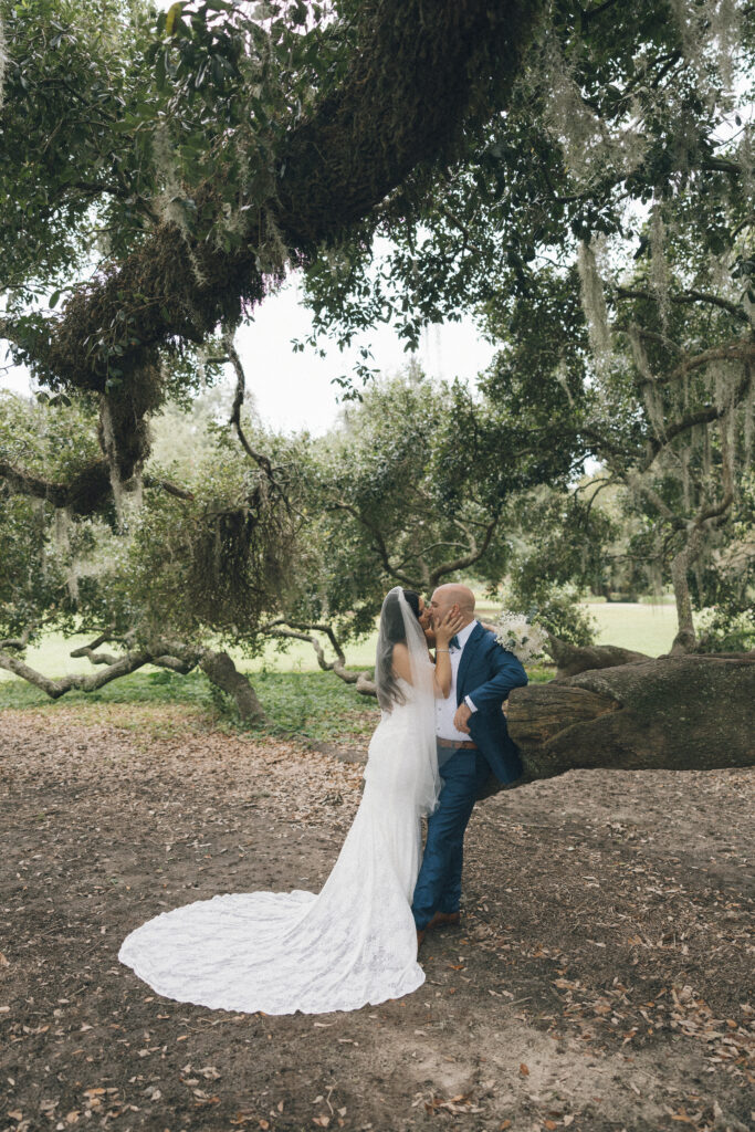 A bride and groom sharing a kiss in a garden in Charleston, SC.