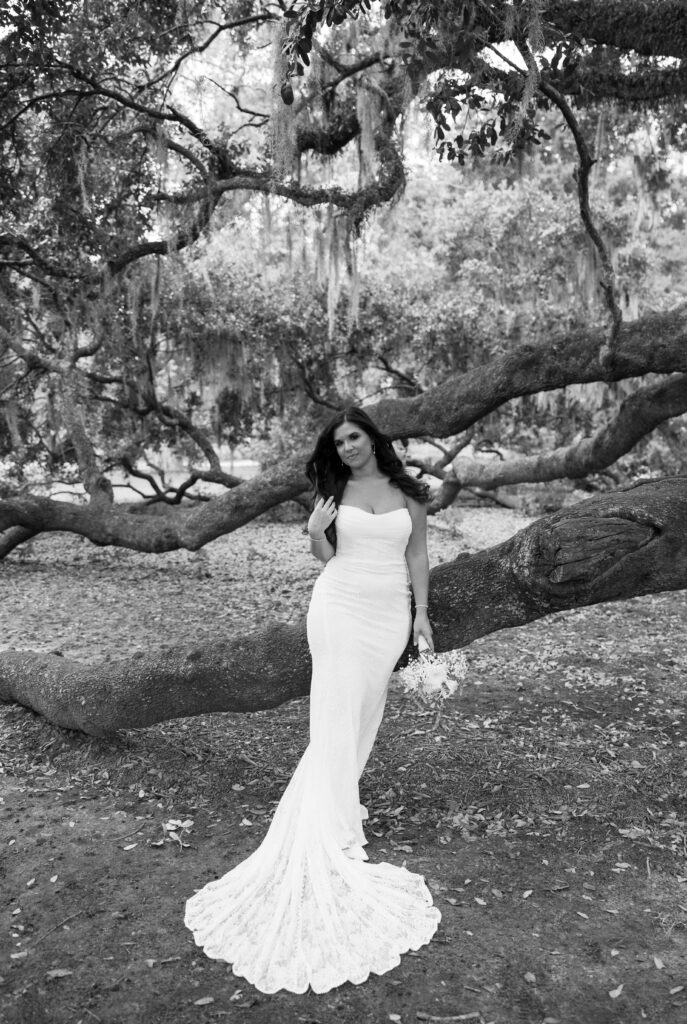 A bride poses against trees in Charleston, SC.