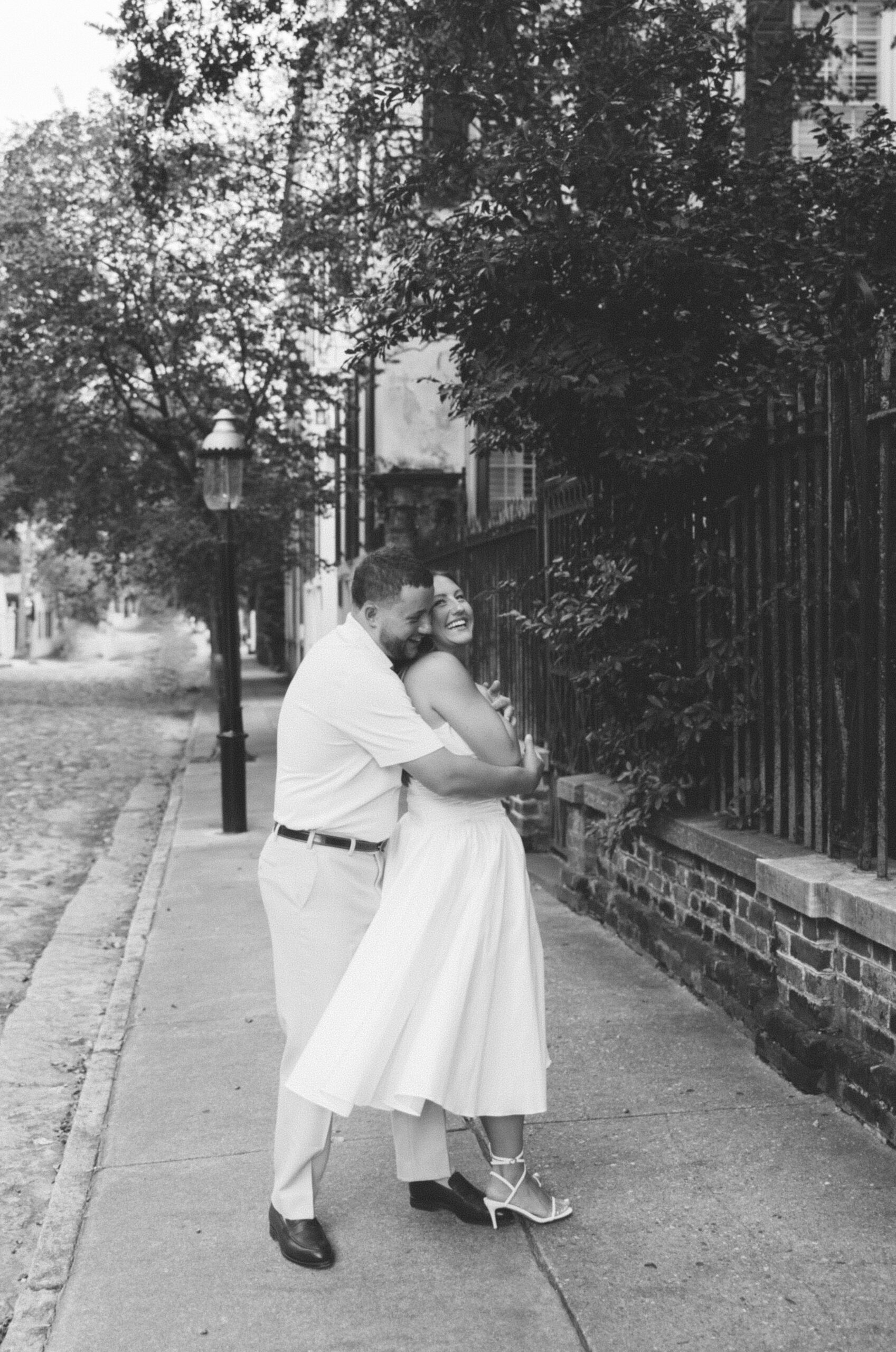 An engaged couple poses for their engagement photos in downtown Charleston, SC.