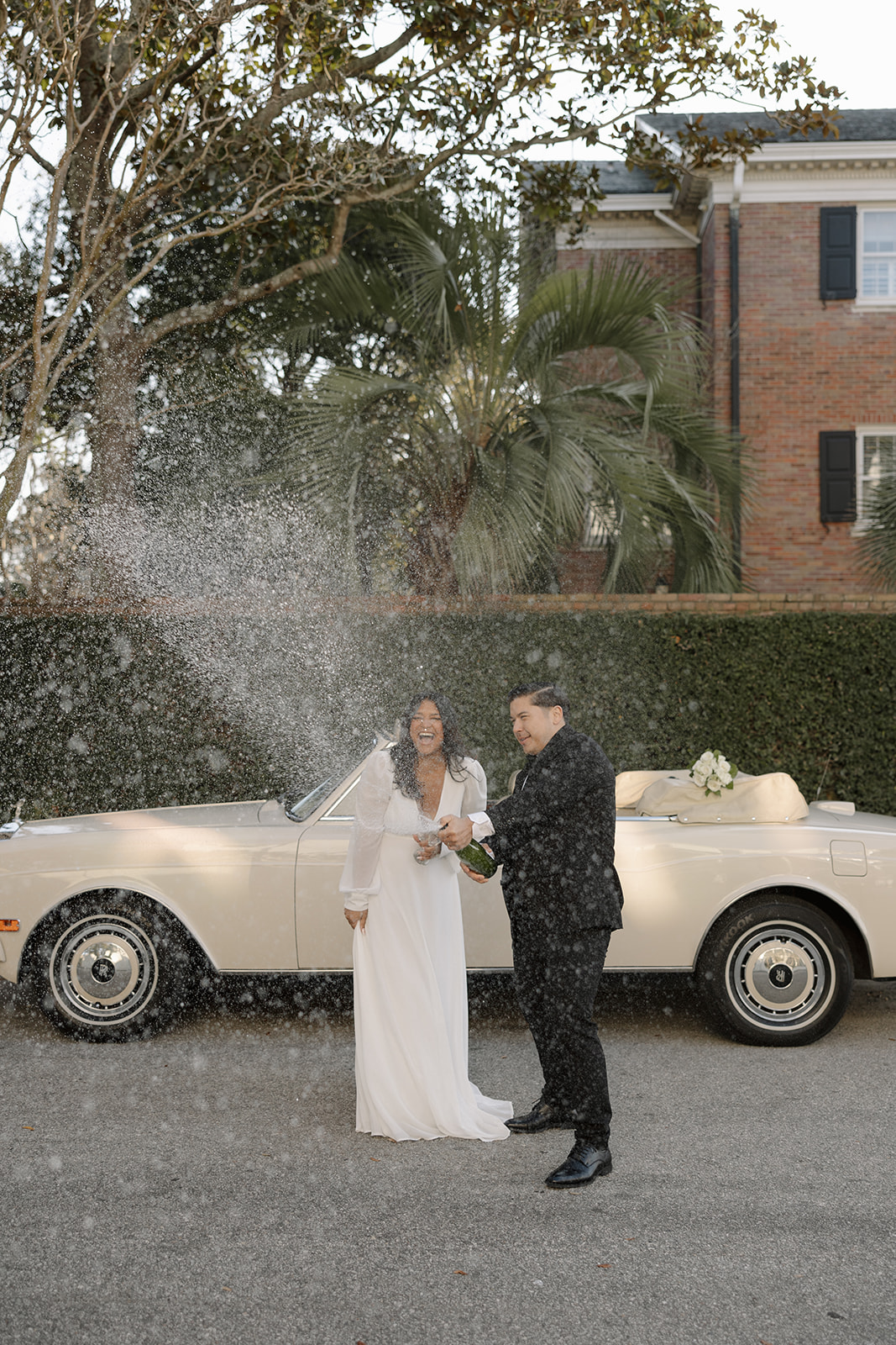 A couple pop champagne at their coastal engagement in Charleston, SC.