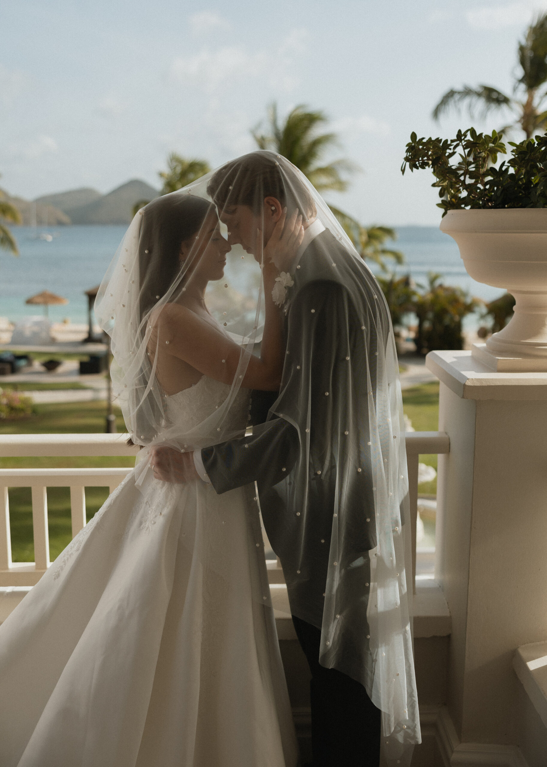 A bride and groom under her veil during their wedding portraits.