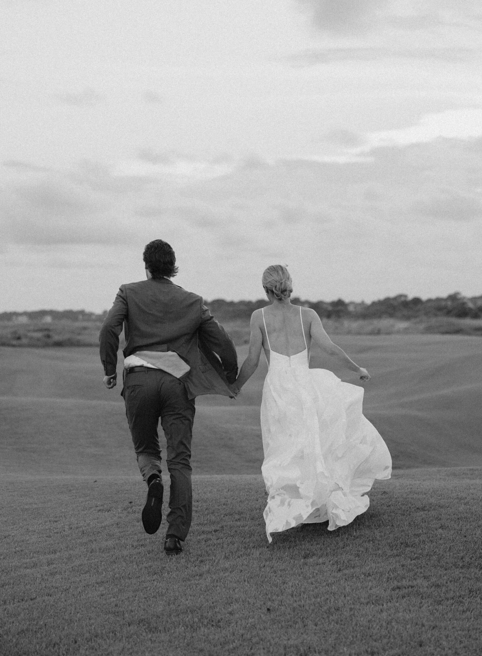 A bride and groom run away together during coastal portraits in South Carolina.